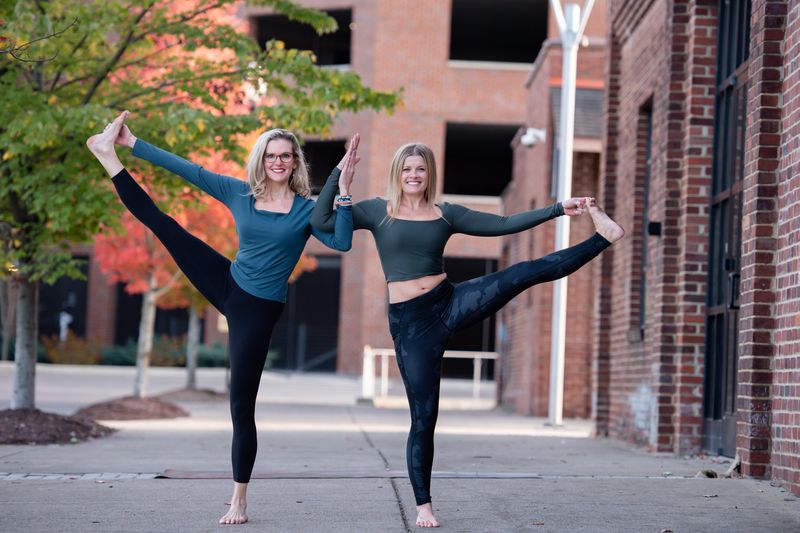 Two teachers side by side in extended hand-to-big-toe pose