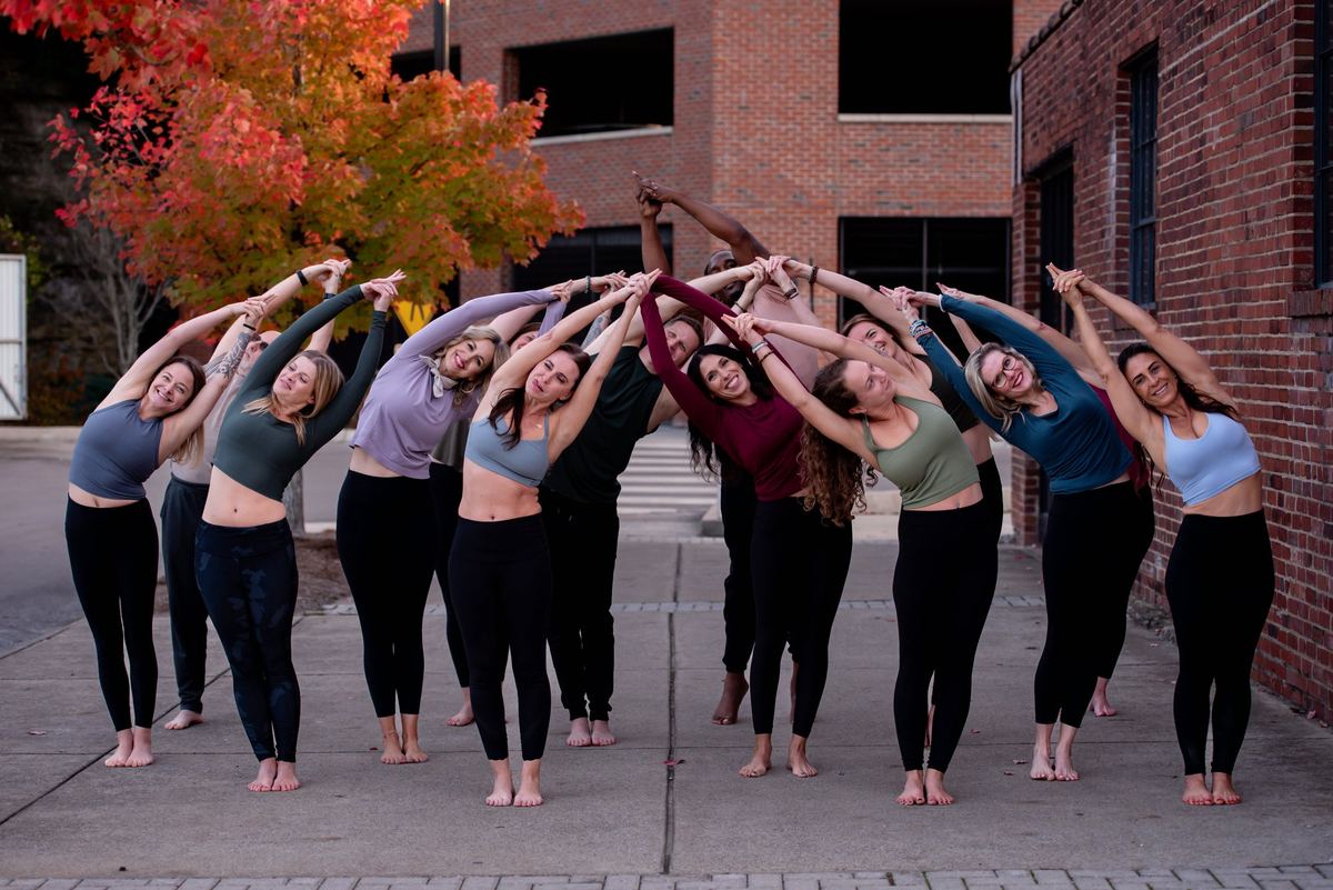 The Donelson Hot Yoga teachers together in a standing side bend